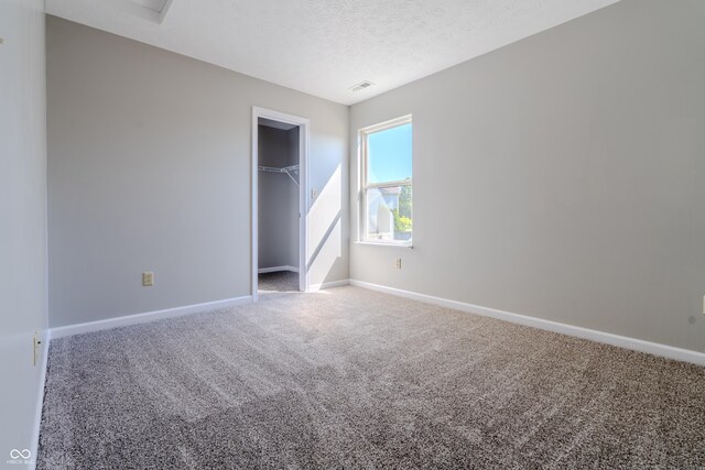 6491 Enclave Blvd, Greenwood, IN 46143 - unfurnished bedroom featuring carpet, baseboards, a closet, and a textured ceiling