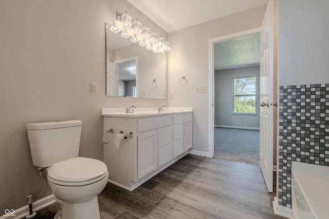 6491 Enclave Blvd, Greenwood, IN 46143 - full bathroom featuring toilet, baseboards, wood finished floors, and double vanity