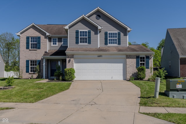 6491 Enclave Blvd, Greenwood, IN 46143 - traditional-style home with brick siding, concrete driveway, an attached garage, and a front lawn