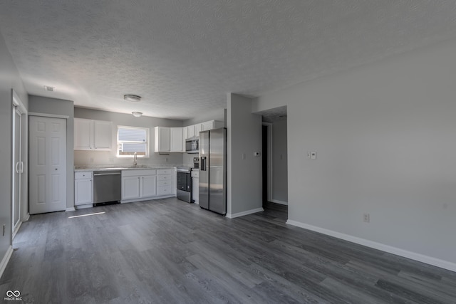 6491 Enclave Blvd, Greenwood, IN 46143 - kitchen featuring appliances with stainless steel finishes, a textured ceiling, dark wood-type flooring, baseboards, and white cabinetry