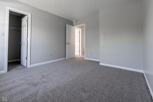6491 Enclave Blvd, Greenwood, IN 46143 - unfurnished bedroom featuring carpet flooring, baseboards, a spacious closet, and a textured ceiling