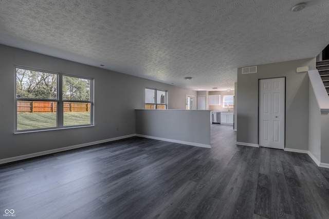 6491 Enclave Blvd, Greenwood, IN 46143 - unfurnished living room with a textured ceiling, dark wood-style flooring, plenty of natural light, and baseboards