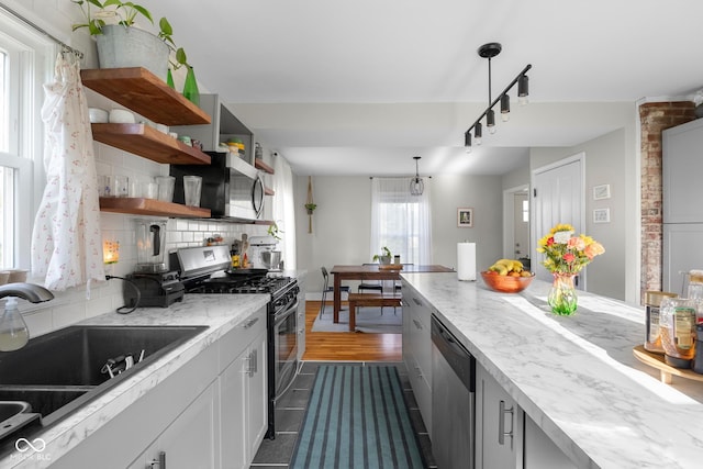 2336 Sycamore St, Columbus, IN 47201 - kitchen with stainless steel appliances, a sink, track lighting, backsplash, and dark tile patterned flooring