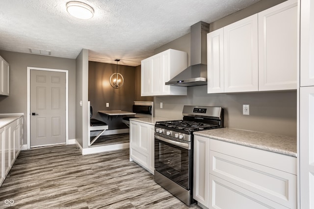 51 Glasgow Ln, Noblesville, IN 46060 - kitchen featuring stainless steel gas stove, wall chimney range hood, light wood finished floors, white cabinets, and light countertops