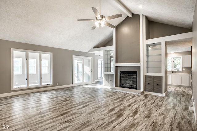 51 Glasgow Ln, Noblesville, IN 46060 - unfurnished living room with a textured ceiling, wood finished floors, a ceiling fan, high vaulted ceiling, and beam ceiling
