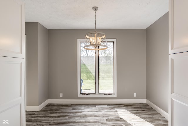 51 Glasgow Ln, Noblesville, IN 46060 - unfurnished dining area with a chandelier, plenty of natural light, wood finished floors, and a textured ceiling