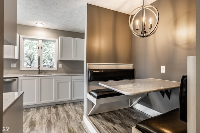 51 Glasgow Ln, Noblesville, IN 46060 - dining space featuring a chandelier, light wood-type flooring, a textured ceiling, and baseboards