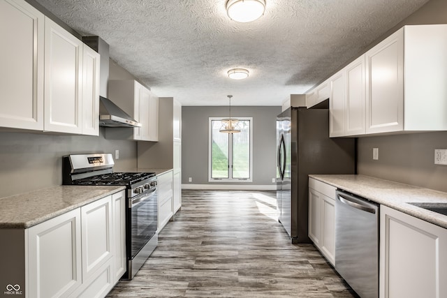 51 Glasgow Ln, Noblesville, IN 46060 - kitchen featuring stainless steel appliances, white cabinets, wood finished floors, light countertops, and a textured ceiling