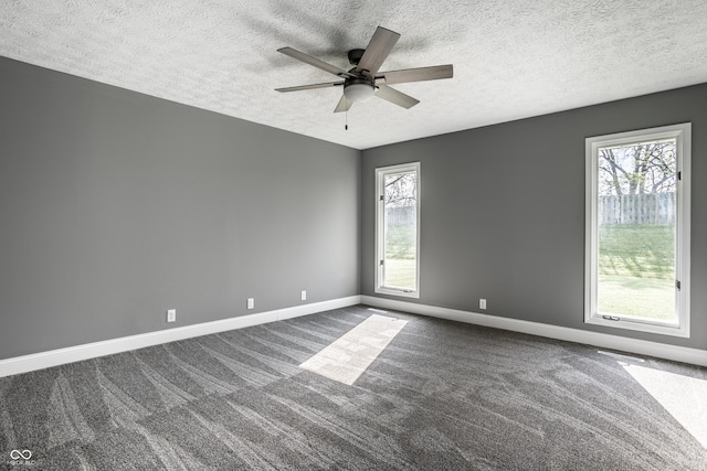 51 Glasgow Ln, Noblesville, IN 46060 - spare room with a textured ceiling, baseboards, ceiling fan, dark carpet, and healthy amount of natural light