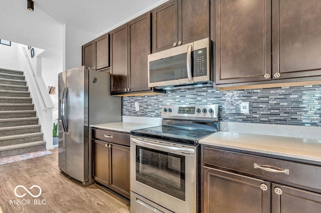 5256 Bramwell Ln, Whitestown, IN 46075 - kitchen with appliances with stainless steel finishes, dark brown cabinetry, light countertops, and light wood-type flooring