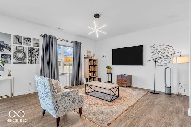 5256 Bramwell Ln, Whitestown, IN 46075 - living room featuring wood finished floors, a chandelier, and baseboards