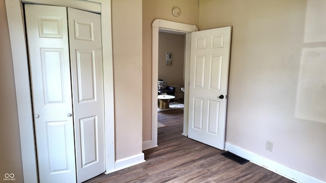1148 N Pershing Ave, Indianapolis, IN 46222 - unfurnished bedroom featuring baseboards, dark wood finished floors, and a closet