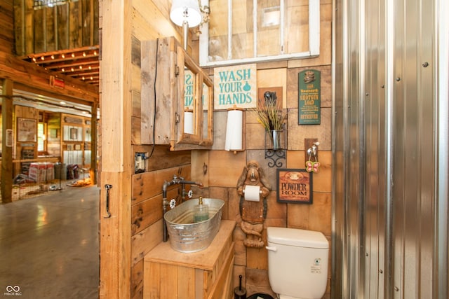 7730 Bear Creek Rd, Morgantown, IN 46160 - bathroom featuring toilet, concrete floors, wood walls, and vanity