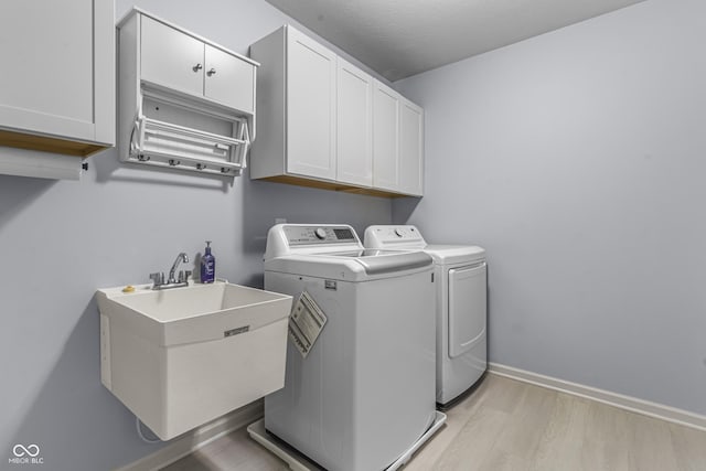 952 Workington Cir, Westfield, IN 46074 - laundry room featuring cabinet space, washing machine and clothes dryer, and light wood-type flooring