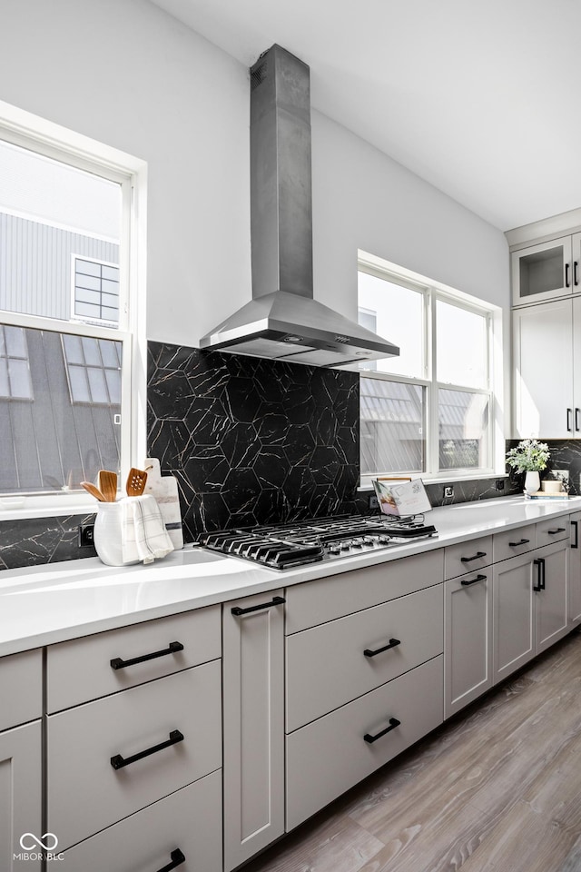 525 Fynn Pl, Indianapolis, IN 46202 - kitchen with wall chimney range hood, stainless steel gas stovetop, tasteful backsplash, light wood finished floors, and gray cabinets