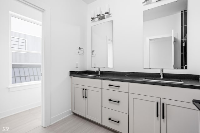 525 Fynn Pl, Indianapolis, IN 46202 - bathroom with baseboards, double vanity, and wood finished floors