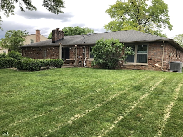 3619 31st St, Columbus, IN 47203 - view of front of property featuring a chimney, brick siding, a front lawn, and central AC