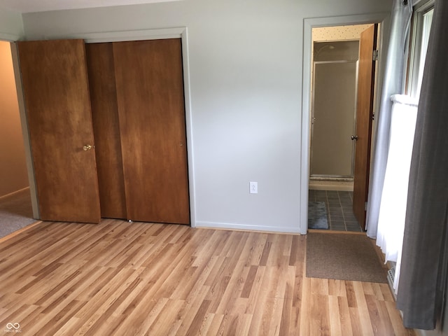 3619 31st St, Columbus, IN 47203 - unfurnished bedroom with light wood-style floors, baseboards, and ensuite bathroom