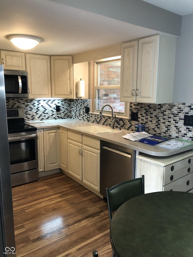 3619 31st St, Columbus, IN 47203 - kitchen featuring appliances with stainless steel finishes, a sink, light countertops, tasteful backsplash, and dark wood-style flooring