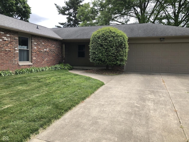 3619 31st St, Columbus, IN 47203 - ranch-style home featuring a garage, concrete driveway, brick siding, a front yard, and roof with shingles