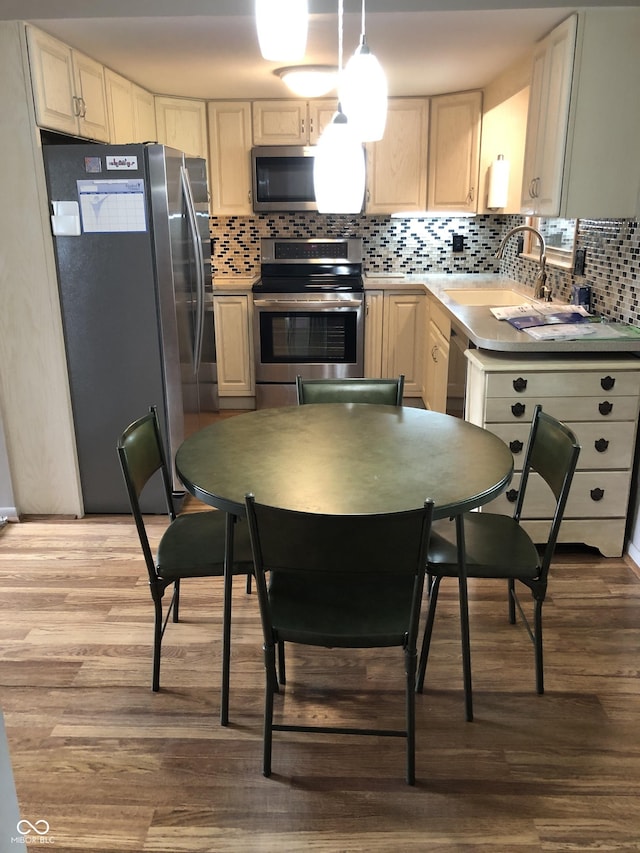 3619 31st St, Columbus, IN 47203 - kitchen featuring appliances with stainless steel finishes, wood finished floors, a sink, and tasteful backsplash