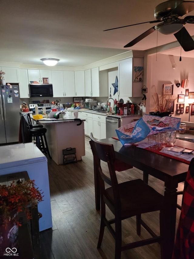 dining space with a ceiling fan and dark wood-style flooring