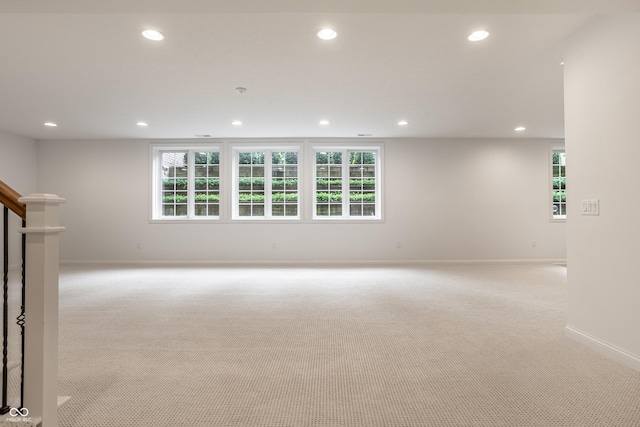 spare room with light carpet, recessed lighting, baseboards, and plenty of natural light