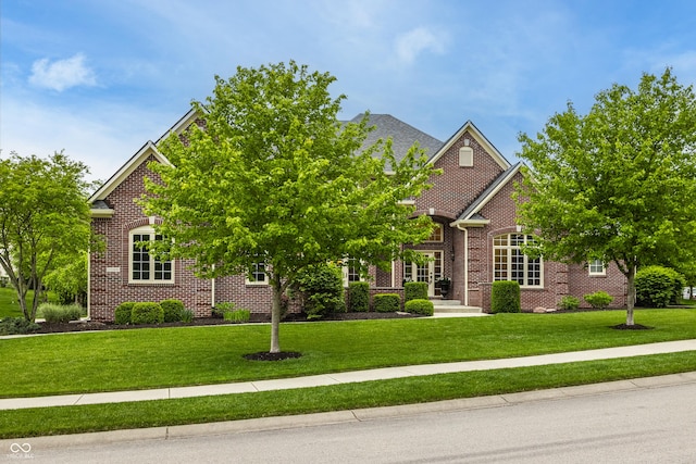 view of front of house with a front lawn and brick siding