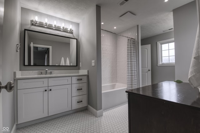 full bathroom with a textured ceiling, baseboards, vanity, and shower / bath combo