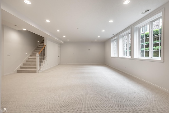 basement featuring recessed lighting, stairway, light colored carpet, and baseboards