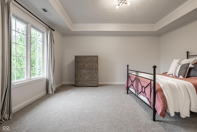 carpeted bedroom featuring ornamental molding, multiple windows, a tray ceiling, and baseboards