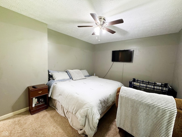 bedroom featuring carpet floors, a ceiling fan, baseboards, and a textured ceiling