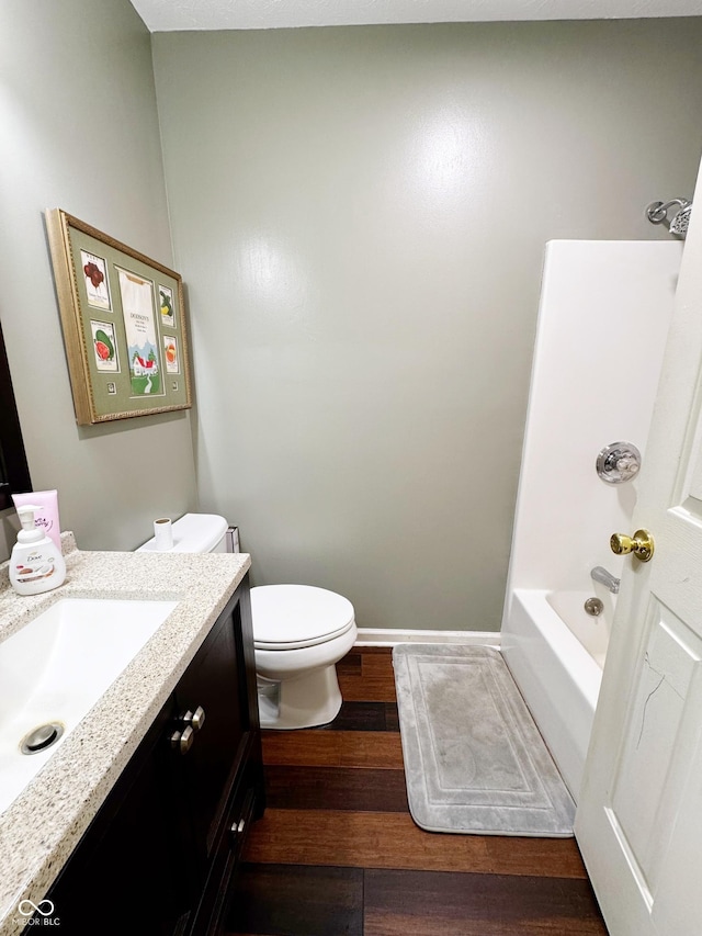 full bathroom featuring vanity, wood finished floors, toilet, baseboards, and shower / tub combination
