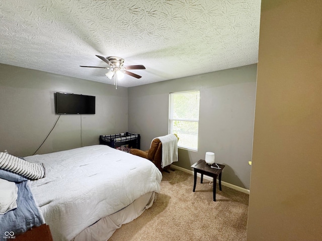 bedroom with light colored carpet, a ceiling fan, baseboards, and a textured ceiling