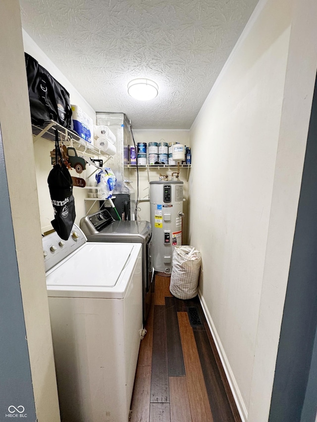 clothes washing area with hybrid water heater, independent washer and dryer, dark wood finished floors, and a textured ceiling