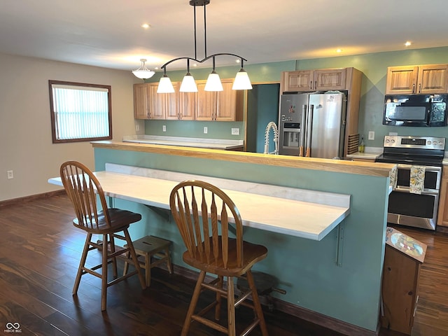 1216 N Cherry St, Rushville, IN 46173 - kitchen with appliances with stainless steel finishes, dark wood-style flooring, light countertops, a large island, and recessed lighting