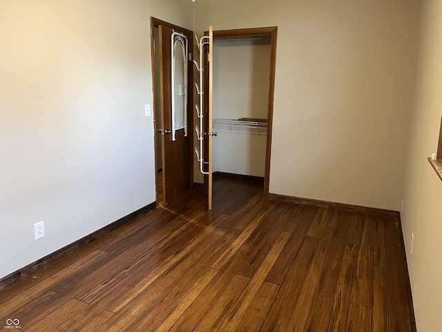1216 N Cherry St, Rushville, IN 46173 - unfurnished bedroom featuring dark wood-style flooring, a closet, and baseboards