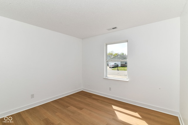 spare room with wood finished floors and baseboards