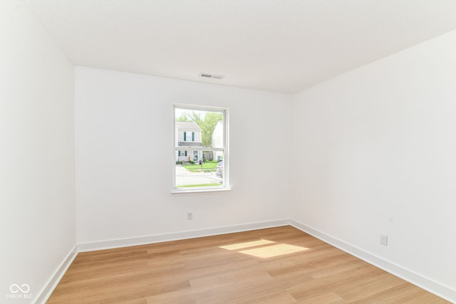 spare room with light wood finished floors and baseboards