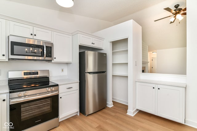 kitchen featuring stainless steel appliances, light countertops, light wood-style flooring, white cabinetry, and a ceiling fan