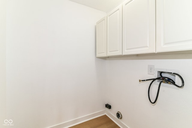 laundry room featuring cabinet space, baseboards, wood finished floors, and hookup for a washing machine