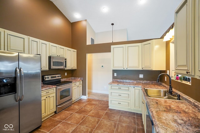 204 Oakview Dr, Mooresville, IN 46158 - kitchen featuring stainless steel appliances, a sink, cream cabinets, high vaulted ceiling, and baseboards