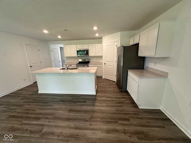 6712 Rawlings Ln, Indianapolis, IN 46221 - kitchen with appliances with stainless steel finishes, white cabinetry, recessed lighting, dark wood finished floors, and a kitchen island with sink