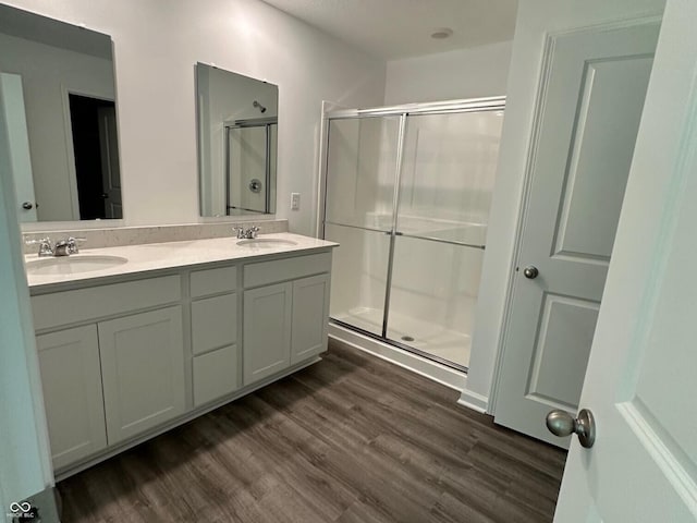 6712 Rawlings Ln, Indianapolis, IN 46221 - bathroom with a shower stall, wood finished floors, and double vanity