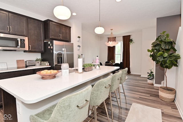 3110 W New York St, Indianapolis, IN 46222 - kitchen featuring stainless steel appliances, dark brown cabinetry, baseboards, light countertops, and recessed lighting