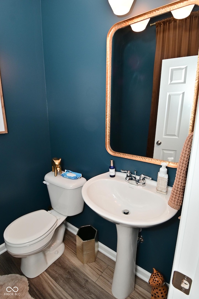 3110 W New York St, Indianapolis, IN 46222 - half bathroom with baseboards, toilet, and wood finished floors