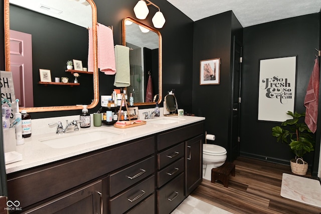 3110 W New York St, Indianapolis, IN 46222 - bathroom with wood finished floors, toilet, and double vanity