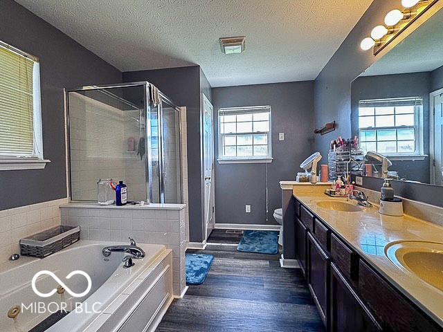 6155 W Bayfront, Mccordsville, IN 46055 - full bath with a stall shower, wood finished floors, a garden tub, double vanity, and a textured ceiling