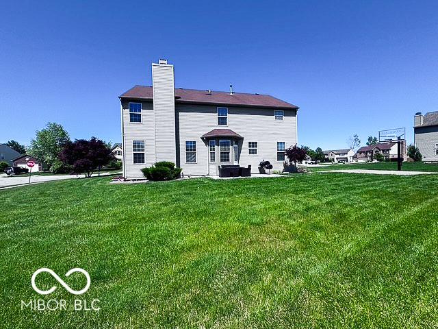 6155 W Bayfront, Mccordsville, IN 46055 - back of property with a chimney and a lawn