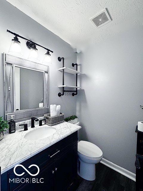6155 W Bayfront, Mccordsville, IN 46055 - bathroom featuring vanity, wood finished floors, baseboards, toilet, and a textured ceiling